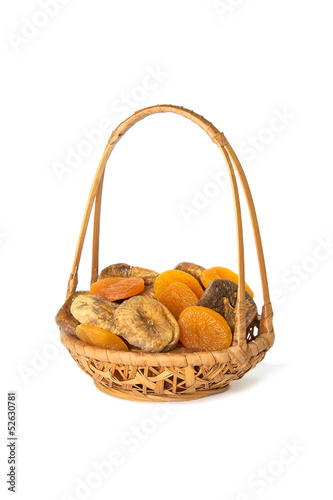 Dried apricots and figs in a wicker basket isolated on white