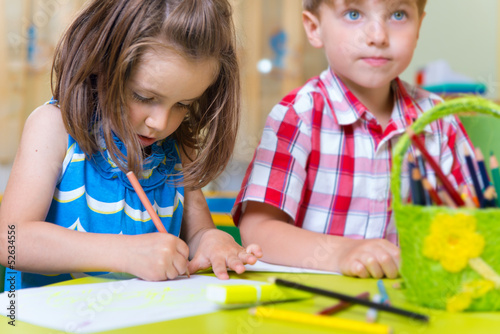 Two cute little prescool kids drawing photo