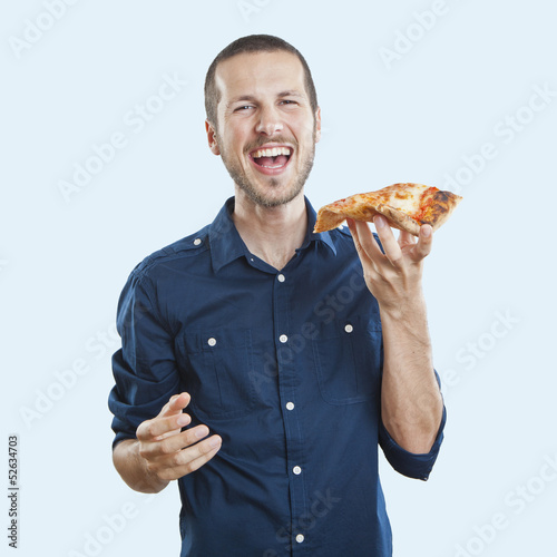 portrait of a young beautiful man eating a slice of pizza marghe