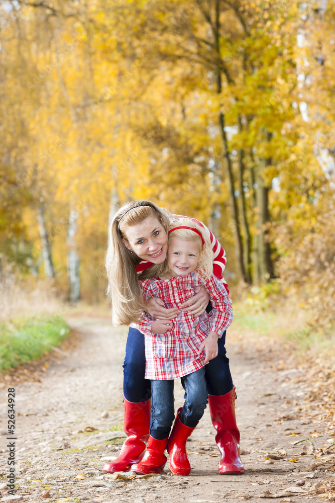 mother with her daughter in autumnal alley mother with her daughter in autumnal alley