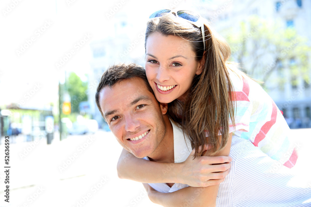 Fototapeta premium Man giving piggyback ride to girlfriend