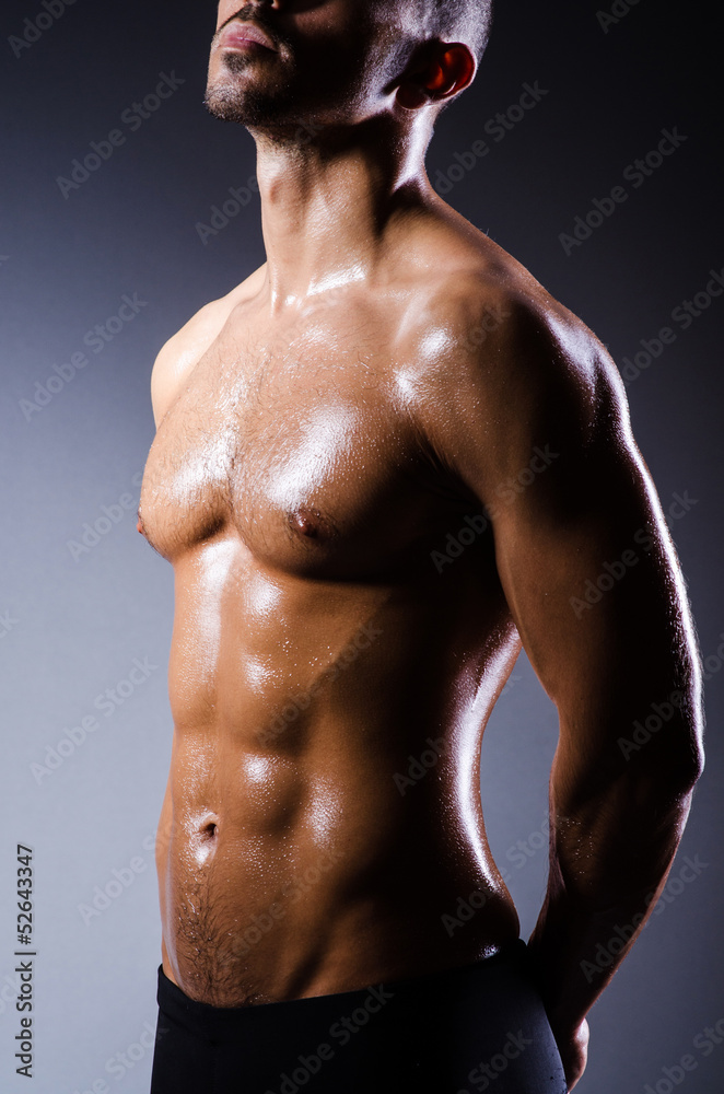Fototapeta premium Muscular man in dark studio