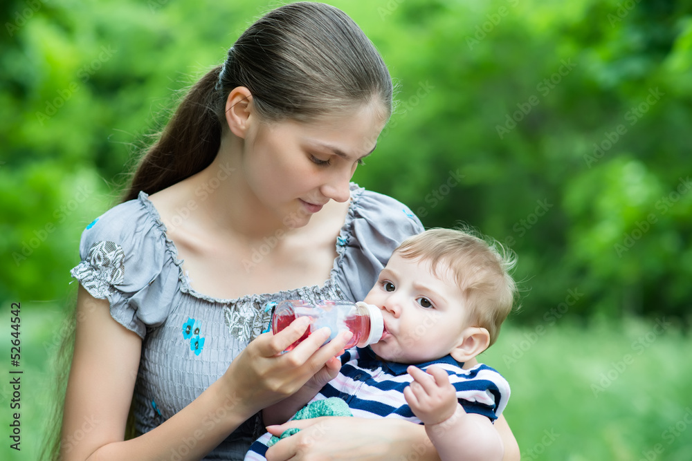 Young mother feeds her baby with a bottle Young mother feeds her baby with a bottle