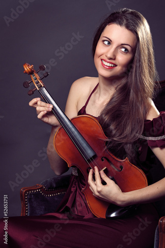 Happy and funny expression of a beautiful violin musician