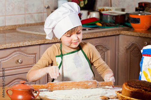 lovely girl in a chef's hat cooking sweet cake