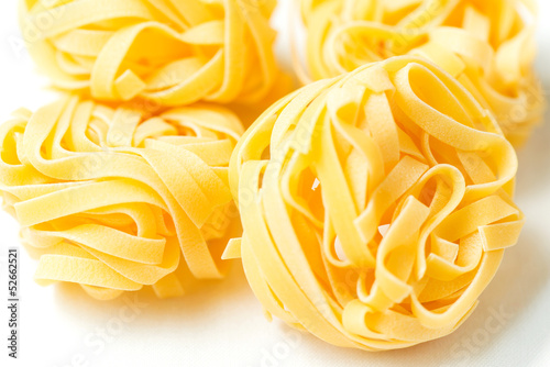 Dry pasta tagliatelle on tablecloth