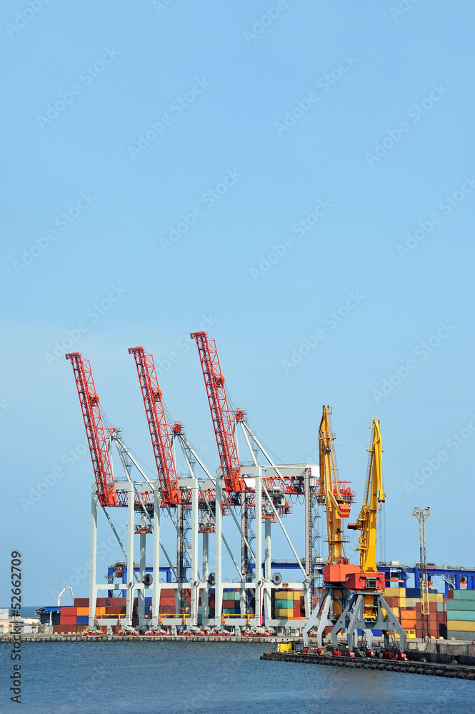 Port cargo crane and container over blue sky background