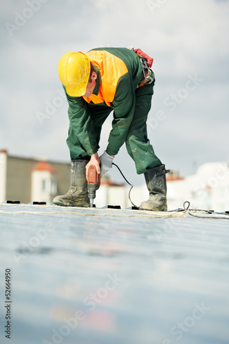 фотографія Worker builder roofer at metal profile work