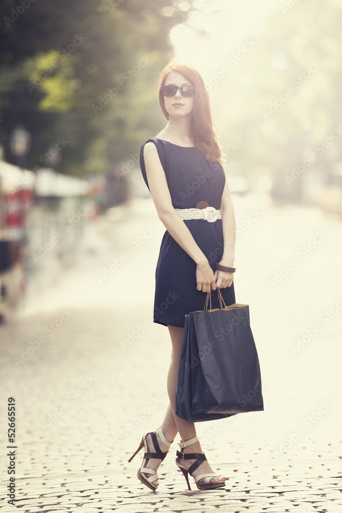 Young woman with shopping bags walking on the city street Young woman with shopping bags walking on the city street