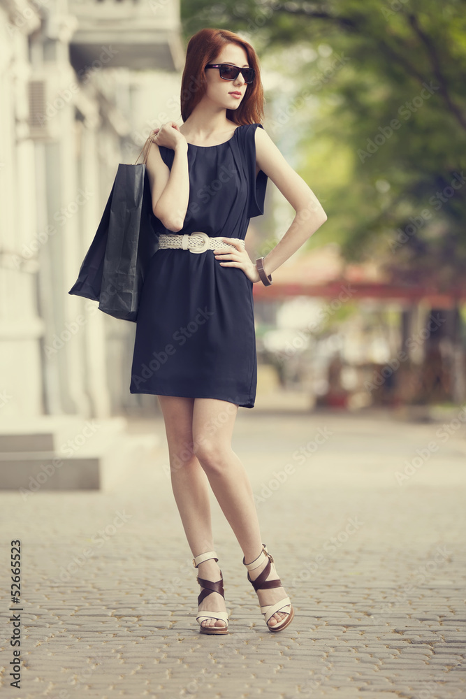 Young woman with shopping bags walking on the city street