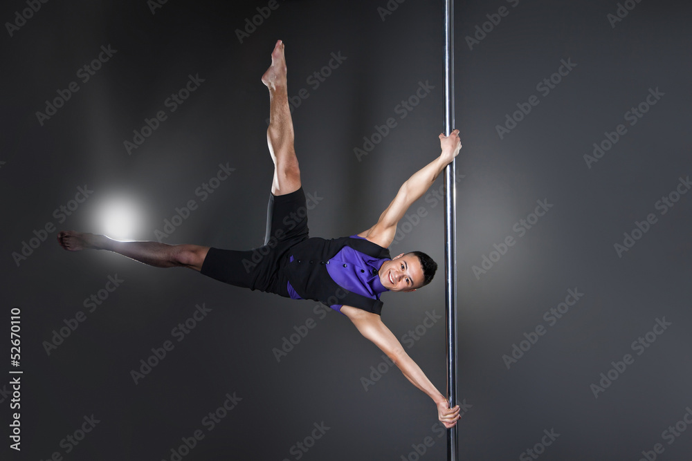 Pole dance man over black background with flashes Pole dance man over black background with flashes