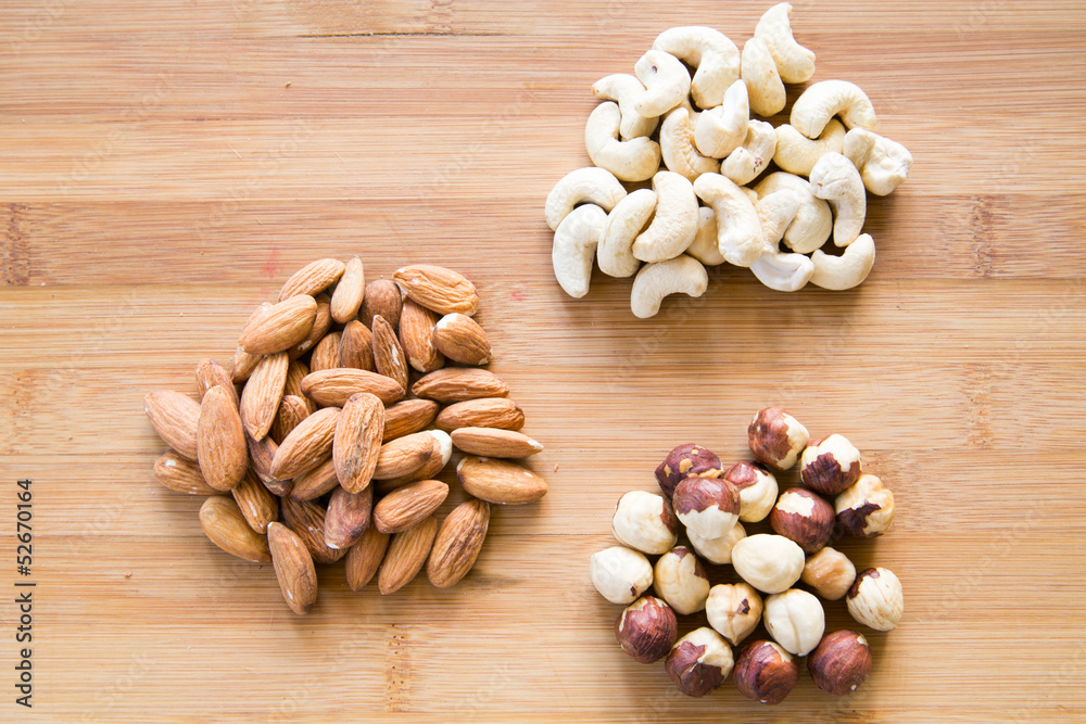 Three piles of nuts on a wooden board Three piles of nuts on a wooden board