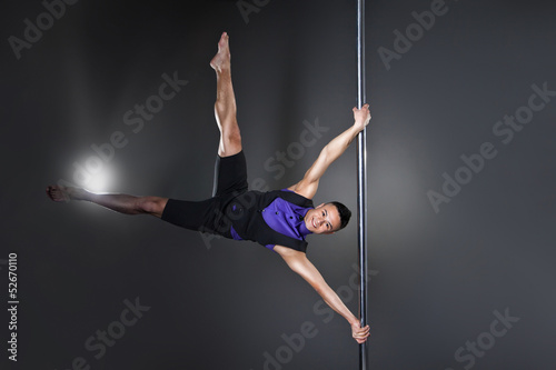 Pole dance man over black background with flashes