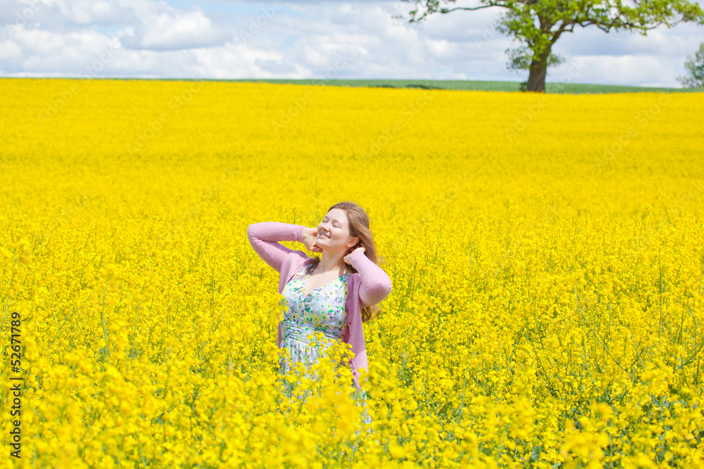 Fototapeta premium lachende frau im raps feld