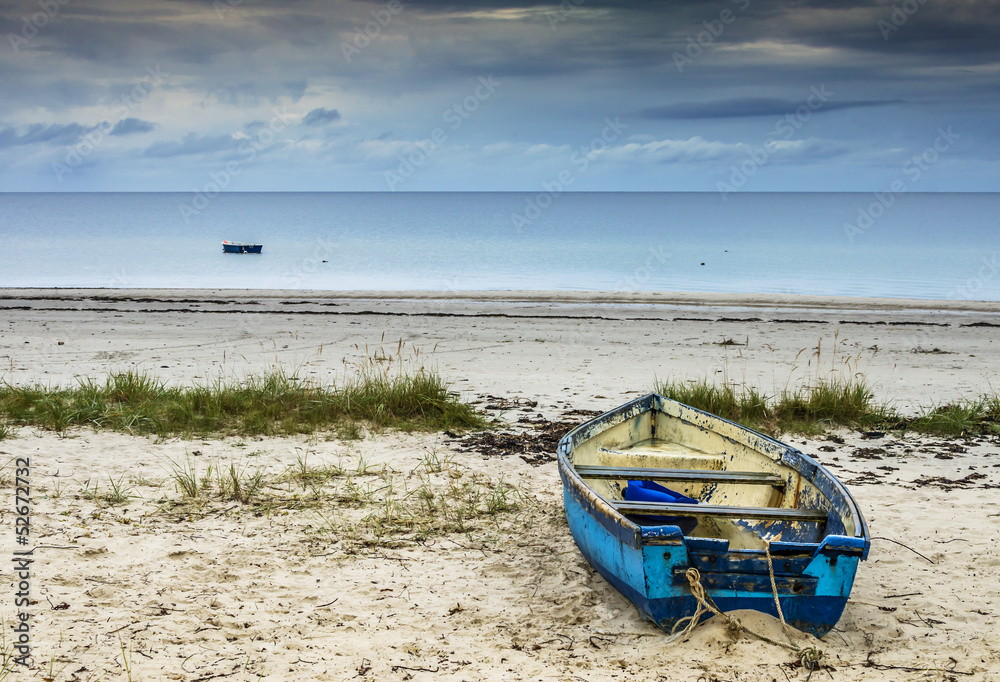 The old fishing boat on sandy beach of the Baltic Sea The old fishing boat on sandy beach of the Baltic Sea