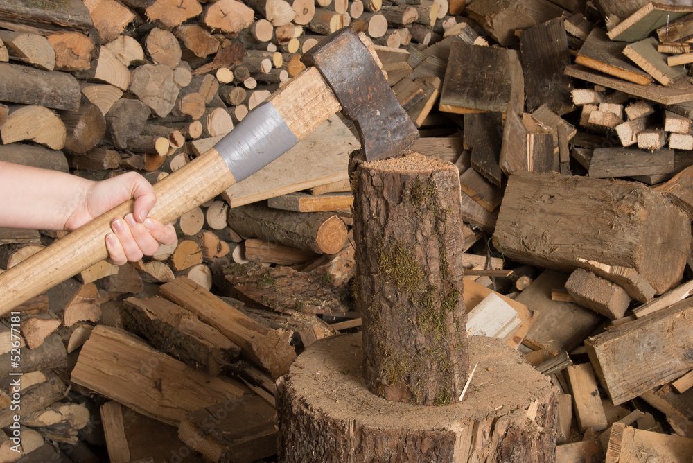 Großes Stück Holz hacken mit Axt, Holzscheiter im Hintergrund Großes Stück Holz hacken mit Axt, Holzscheiter im Hintergrund