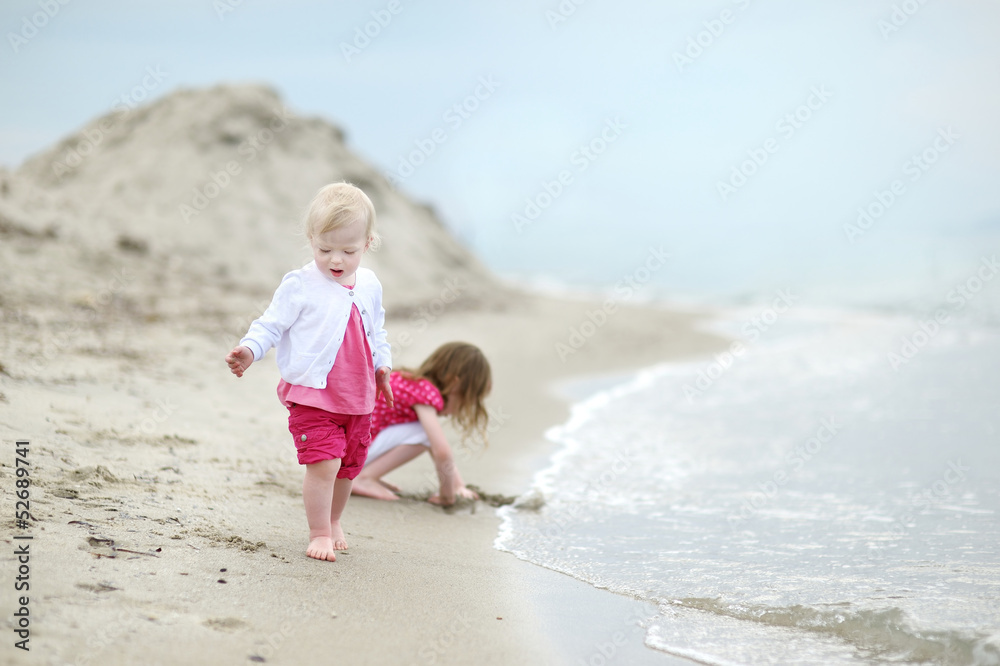 Naklejka premium Adorable toddler girl on a sandy beach