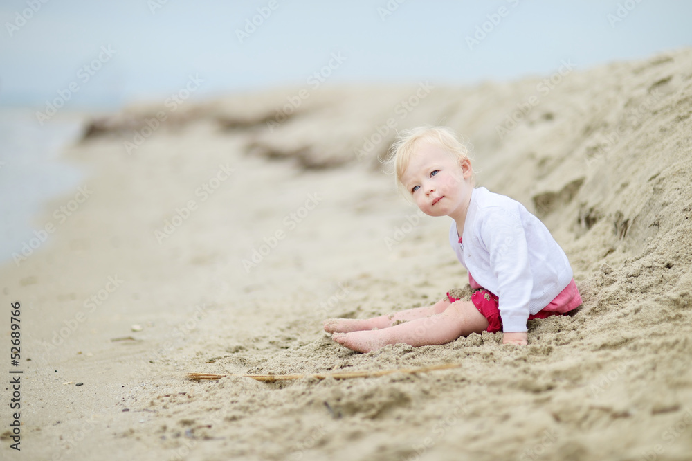 Adorable toddler girl on a sandy beach Adorable toddler girl on a sandy beach