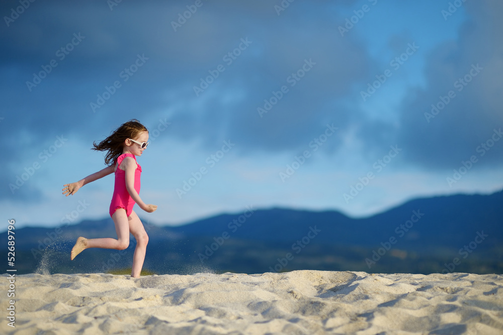 Adorable little girl playing on a sandy beach Adorable little girl playing on a sandy beach