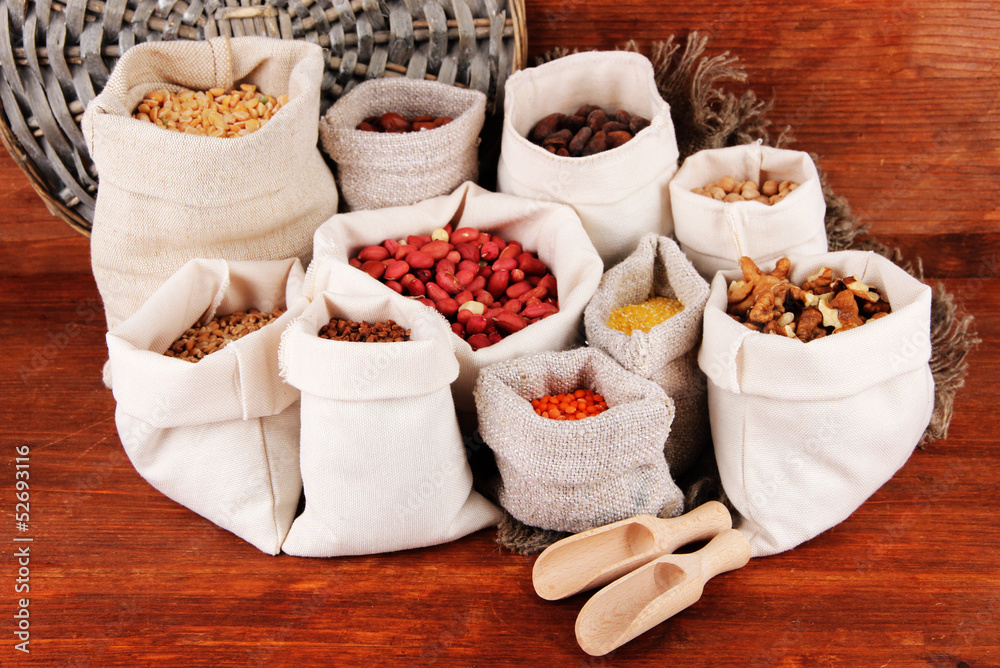 Different kinds of beans in sacks on wooden background Different kinds of beans in sacks on wooden background