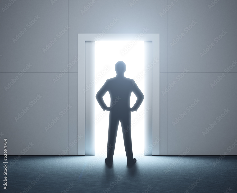 Fototapeta premium Silhouette of a man and opened doorway