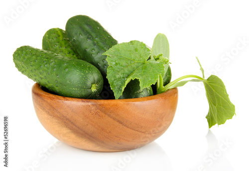 Tasty green cucumbers in wooden bowl, isolated on white