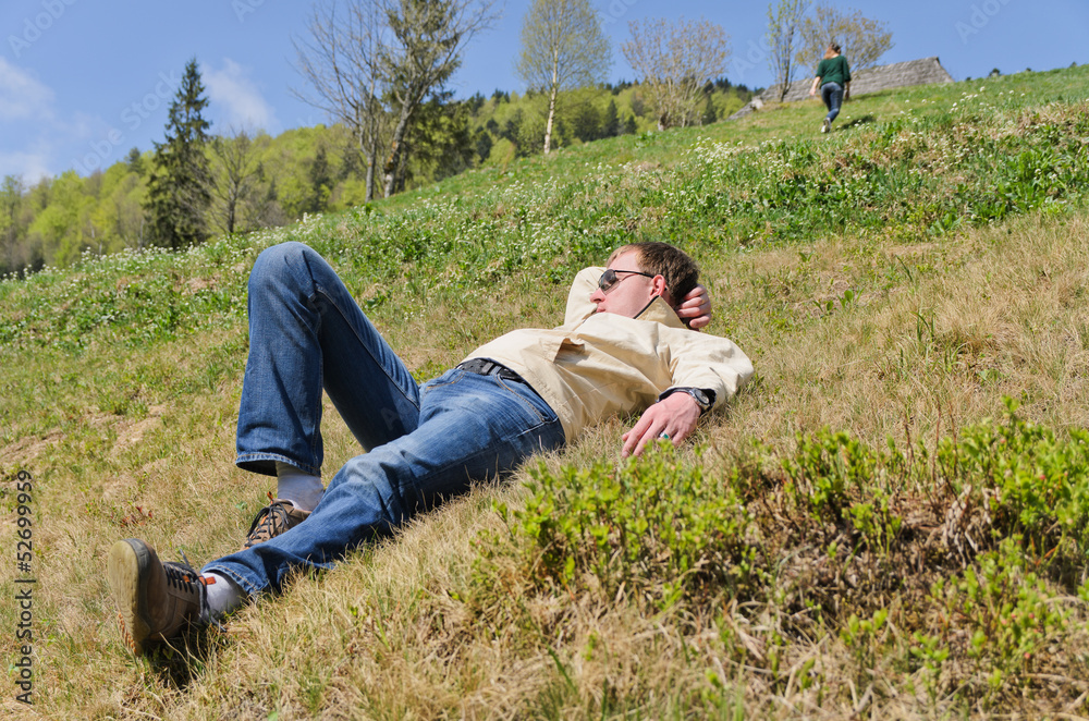 Naklejka premium Man lying on a steep hillside