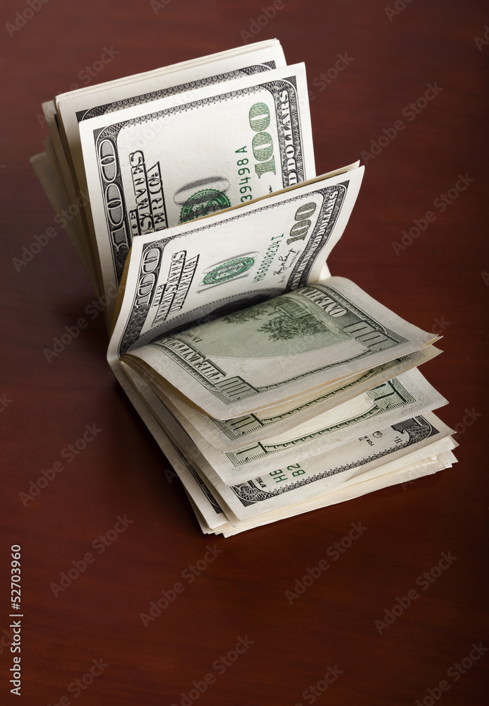 Folded 100 US$  Bills Stack on Brown Background