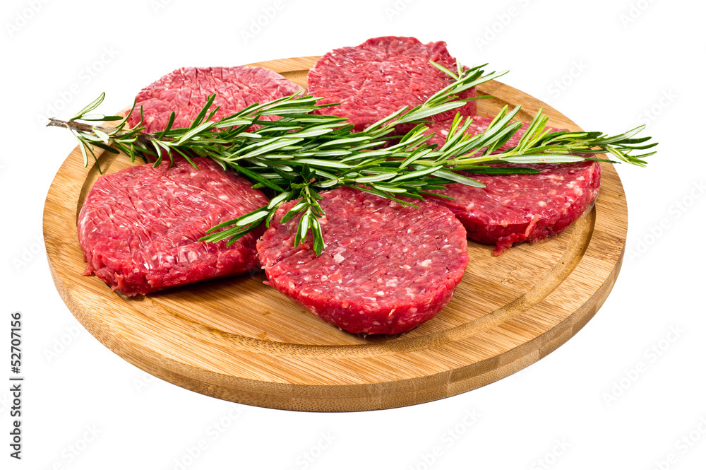 raw hamburgers with cellophane and rosemary on wooden board