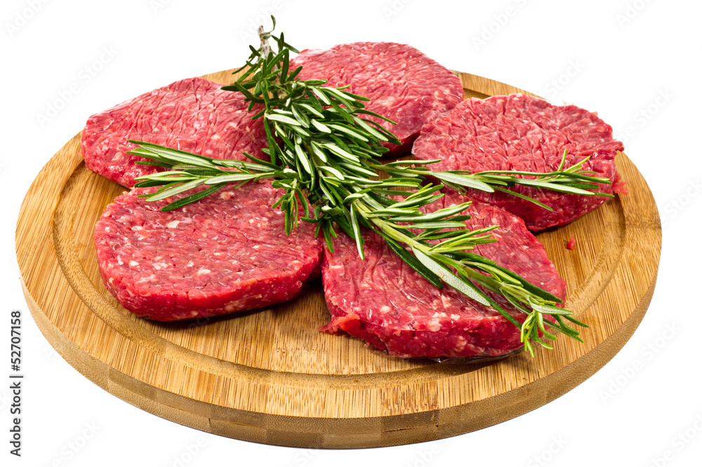 raw hamburgers with cellophane and rosemary on wooden board