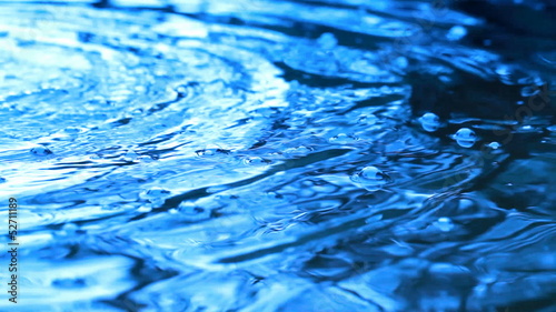 Bright shining blue water surface with ripple bubbles