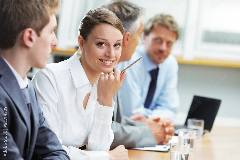 Smiling woman sitting at a business meeting with colleagues Smiling woman sitting at a business meeting with colleagues