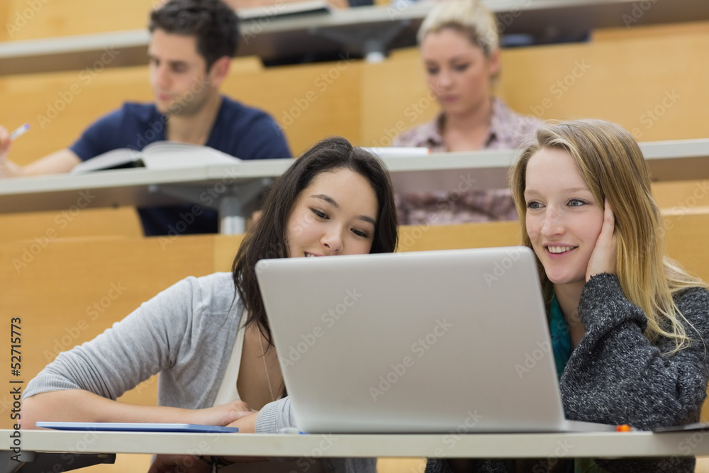 Students in a lecture hall with a laptop Students in a lecture hall with a laptop