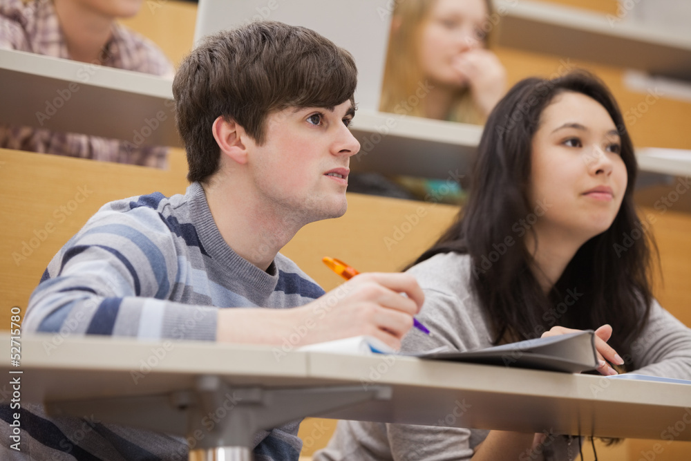 Students paying attention while sitting in a lecture hall