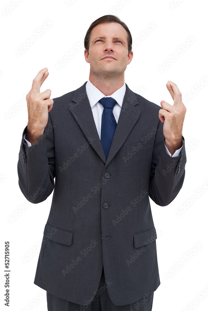 Serious businessman with fingers crossed is looking up Serious businessman with fingers crossed is looking up