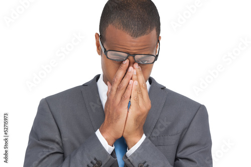 фотографія Young businessman with glasses holding his head between hands
