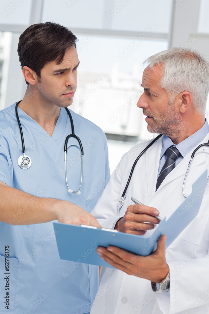 Serious doctors talking about file Serious doctors talking about file