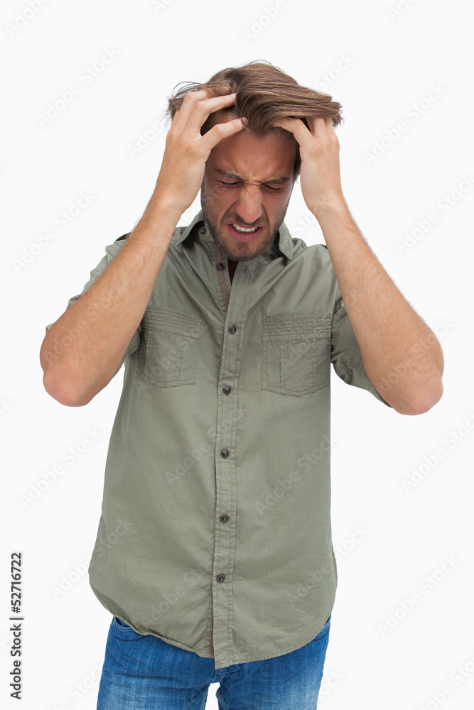 Frustrated man pulling his hair and looking down Frustrated man pulling his hair and looking down