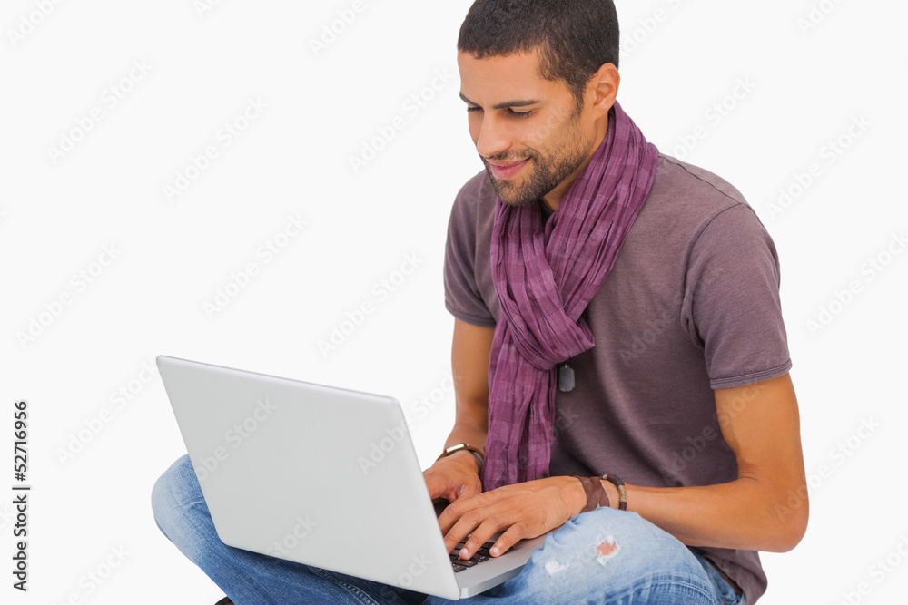 Smiling man sitting on floor using laptop Smiling man sitting on floor using laptop
