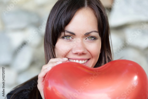 Glückliche Frau mit Herzluftballon