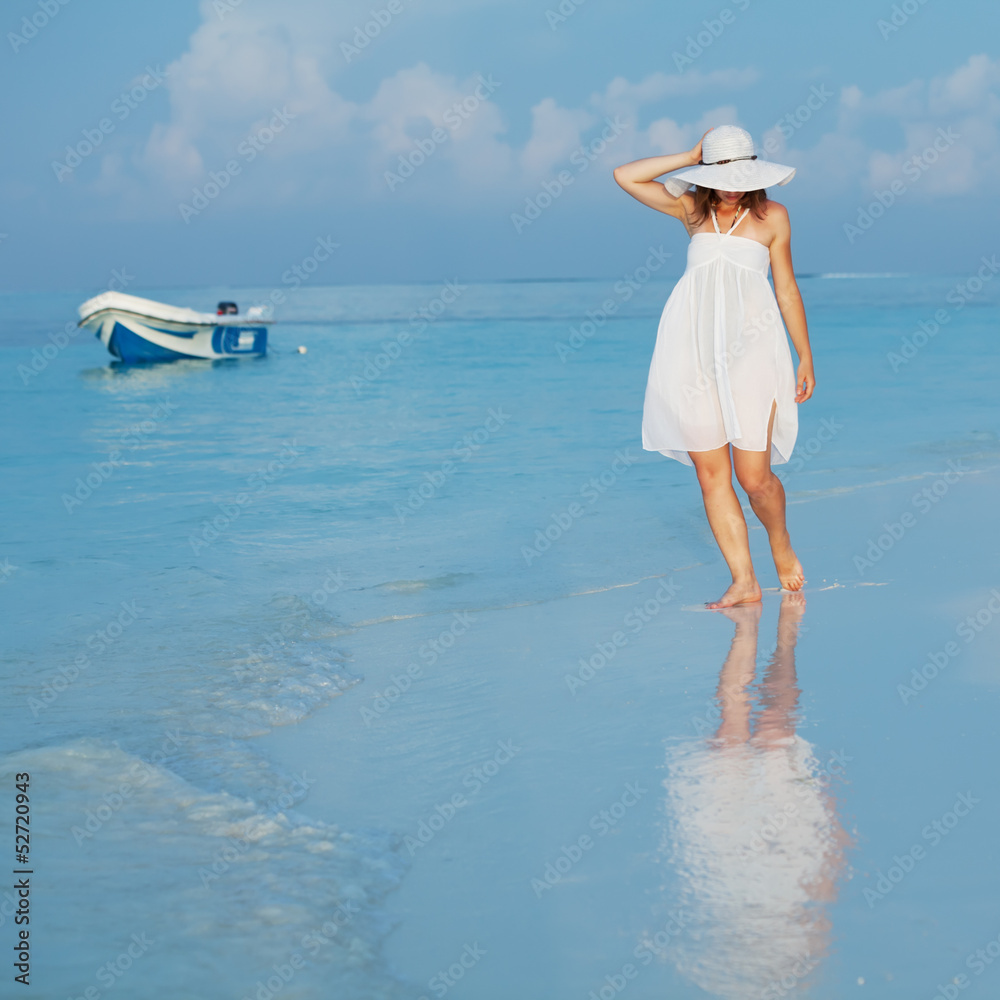 Caucasian woman walks along beautiful seashore Caucasian woman walks along beautiful seashore