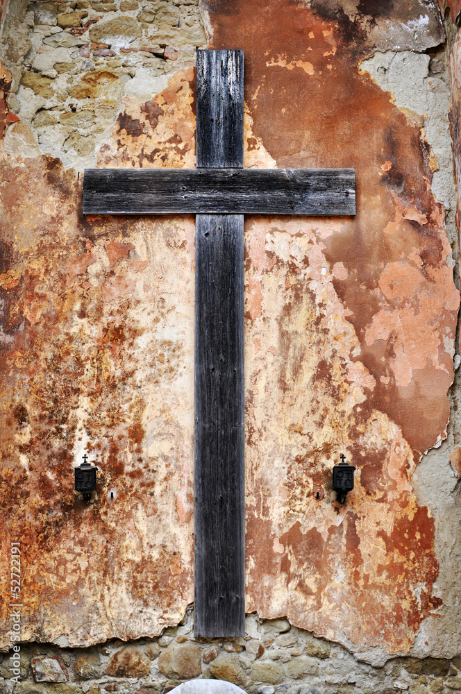Croce in legno su vecchio muro