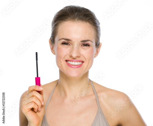Beauty portrait of happy young woman holding mascara brush