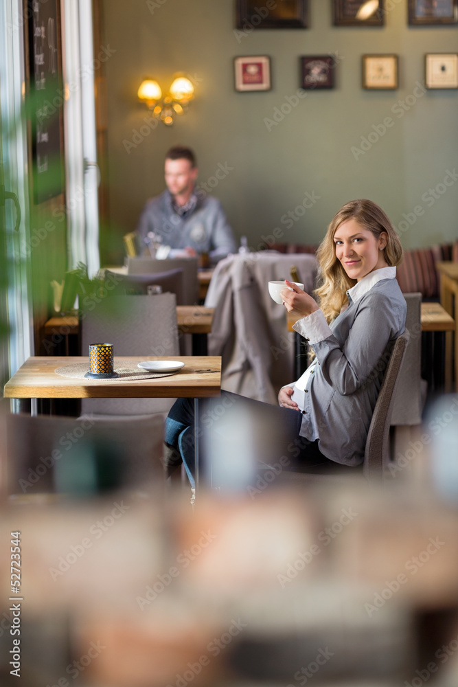Pregnant Woman Drinking Coffee At Cafe