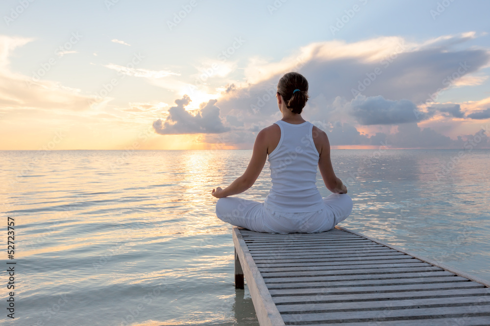 Caucasian woman practicing yoga at seashore