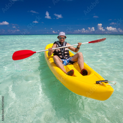 Young caucasian man kayaking in sea at Maldives © Maygutyak