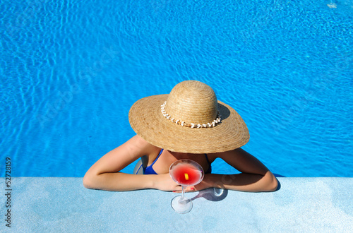 Woman at poolside with cosmopolitan cocktail