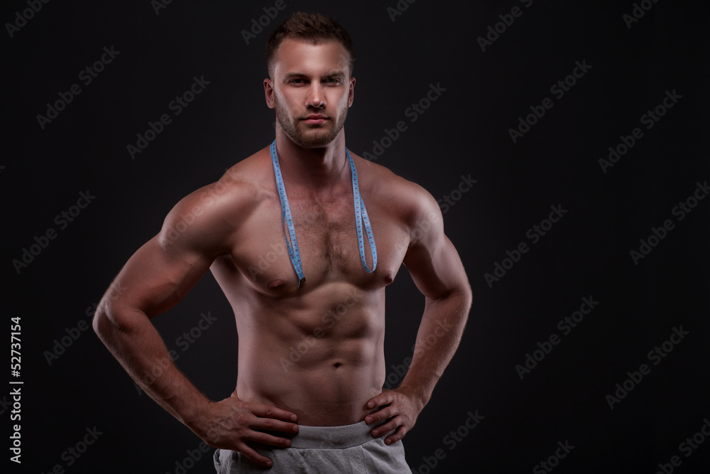 Muscular man with measurement tape