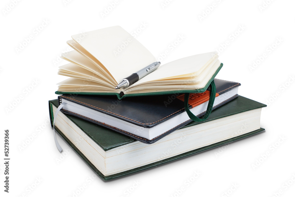 Office notepad and pen on top of the book, close-up. Organiser. Office notepad and pen on top of the book, close-up. Organiser.