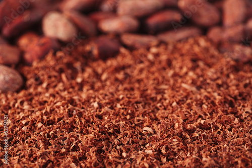 cocoa beans and grated chocolate background, shallow dof